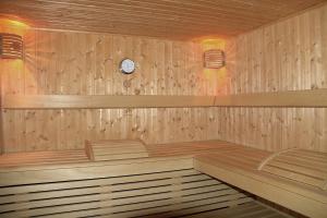 a wooden sauna with a clock on the wall at La Suite Swiss Alps in Davos