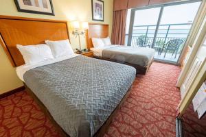 a hotel room with two beds and a large window at Oceanfront Convenience on Lower Floor, Heated Pool in Myrtle Beach