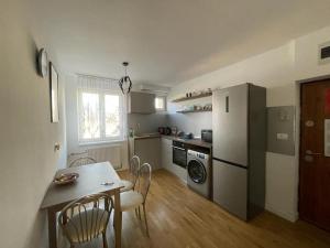a kitchen with a table and chairs and a refrigerator at Lucky Home Timisoara 2 in Timişoara