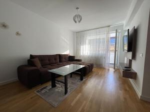 a living room with a brown couch and a table at Lucky Home Timisoara 2 in Timişoara