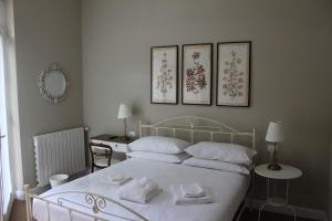 a bedroom with a white bed with three pictures on the wall at Casa Ayd&eacute;e in Bergamo