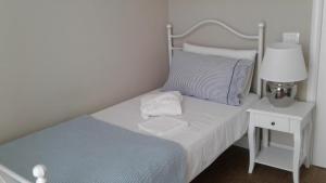 - une petite chambre avec un lit et une table de chevet avec une lampe dans l'établissement Casa Aydée, à Bergame