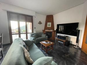 a living room with a couch and a tv at Tuscany Hills Penthouse in Fivizzano