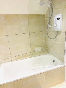 a bathroom with a shower with a bath tub at Buckinghamshire Elegant Studio in Buckinghamshire