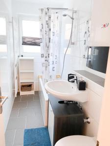 ein weißes Bad mit einem Waschbecken und einem WC in der Unterkunft 1-3 Pers. zentral gelegene, gemütliche Wohnung in Remscheid in Remscheid
