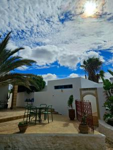 Hotel Villa Soleil في سيدي كاوكي: فناء به طاولة وكراسي أمام المنزل