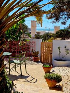 a patio with a table and a bench and plants at Hotel Villa Soleil in Sidi Kaouki