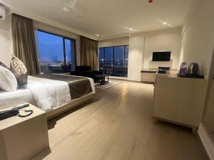 a bedroom with a large bed and a large window at PRESIDENCY AIRPORT HOTEL in Cochin