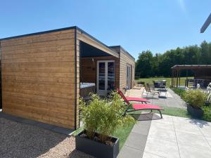 ein kleiner Holzschuppen mit einem Tisch und Bänken in der Unterkunft Mini Love Room jacuzzi privatif in Uriménil