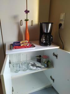 ein Regal mit Kaffeemaschine und Brille darauf in der Unterkunft Ο κόκορας in Artemida
