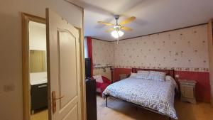 a bedroom with a bed and a ceiling fan at La Grange Des Roches Roses in Anchenoncourt-et-Chazel