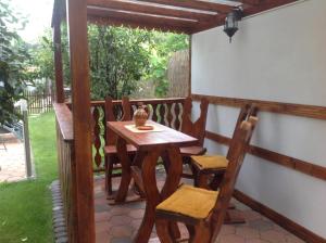 uma mesa de madeira e cadeiras numa varanda em Casa Ioana em Hateg