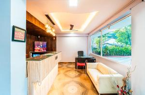 a living room with a couch and a window at Treebo Trend Gulmohar Beach Resort in Calangute