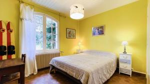een gele slaapkamer met een bed en een raam bij Charmante villa de plain pied à proximité de la plage in La Couarde-sur-Mer