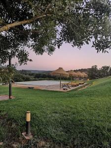 a park with a beach with straw umbrellas at Amieira Agroturismo in Odemira