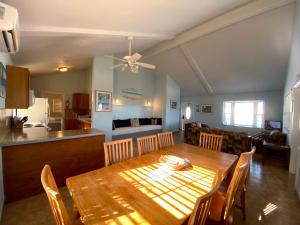a dining room and kitchen with a wooden table and chairs at Hideaways Exuma in Georgetown
