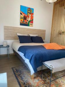 a bedroom with a large bed and a painting on the wall at A LA BELLE ETOILE in Montbrison