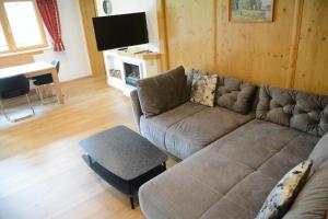 uma sala de estar com um sofá e uma mesa em Appartements Alpenblick em Kirchberg in Tirol