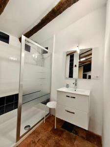 uma casa de banho branca com um lavatório e um chuveiro em Buhardilla Rustica Jabugo em Jabugo
