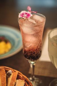 a drink with a flower on top of a table at Pousada Cantelli in Bento Gonçalves