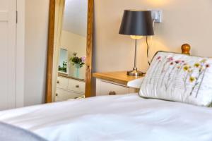 a bedroom with a white bed and a mirror at Howgills Apartments in Sedbergh