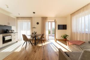 a kitchen and living room with a table and chairs at Apartments Villa Julia in Lana