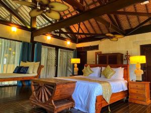 Kudat Riviera Exclusive Beach Villas في كودات: غرفة نوم بسرير كبير وأريكة