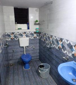 a bathroom with a blue toilet and a sink at Benirosa Homestay Apartments 2 in Velcao