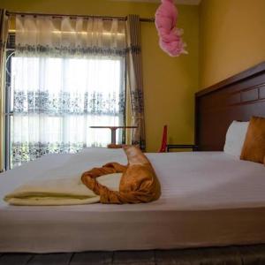 Un pat sau paturi într-o cameră la Kakiri Gardens and Hotel