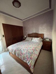 um quarto com uma cama com colcha floral em Calm apartment with a comfy queen bed in Fez 4th floor em Fez