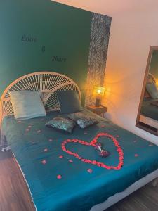 Una cama con un corazón hecho de flores. en Suite Cosy&Jacuzzi, en Cenon