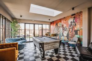 a room with a pool table and a mural at Stay Charmed in Jabbeke