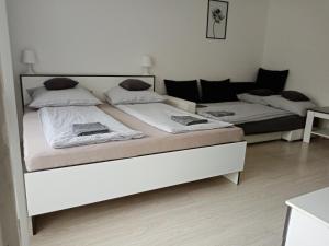 A bed or beds in a room at Grey Harmony Apartman
