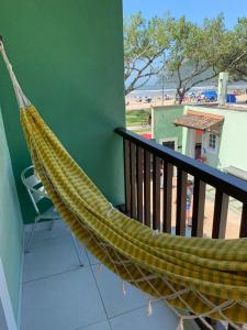 a hammock on a balcony with a view of the beach at Recanto Vista Mar in Bertioga