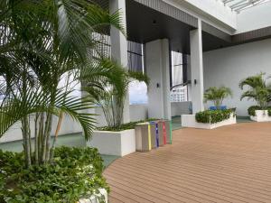 un pasillo con palmeras y plantas en un edificio en GS home en Nusajaya
