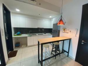 a kitchen with a table and two bar stools at GS home in Nusajaya