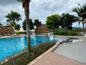 a swimming pool in a resort with a palm tree at GS home in Nusajaya