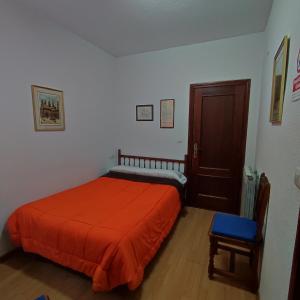 sypialnia z łóżkiem z pomarańczowym kocem w obiekcie Pensión Ciudad Navarro Ramos w Grenadzie