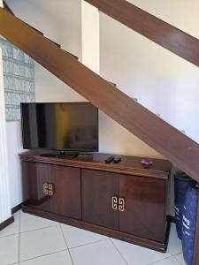 a flat screen tv sitting on top of a wooden entertainment center at Vilage Taipan 02 - Praia Stella Maris in Salvador