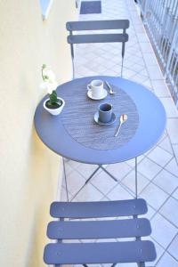 un tavolo blu con due tazze e una pianta sopra di Casa Laita a Sarego
