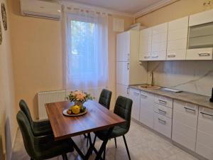 a kitchen with a wooden table with chairs and a vase of flowers at ORI Passion Apart. Malul Mureșului in Arad