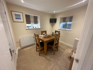a dining room with a wooden table and chairs at The Barn in South Witham