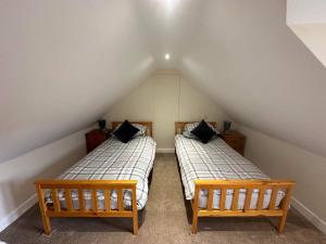 two twin beds in a attic room with two beds sidx sidx sidx at The Barn in South Witham