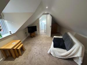 a attic room with a couch and a table at The Barn in South Witham