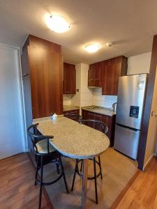 a kitchen with a table and chairs and a refrigerator at Departamento Central en Calama in Calama