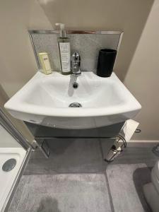 lavabo blanco en un baño junto a un aseo en The Barn, en South Witham