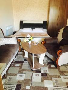 een kamer met 2 bedden en een tafel en een bank bij Norik guest house in Garni
