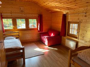 Cabaña de madera con sofá rojo y ventanas en Apartment The Amethyst en Evolène