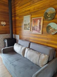 a couch sitting in a living room with wooden walls at Cabanas da Fazenda / 02 in Gramado