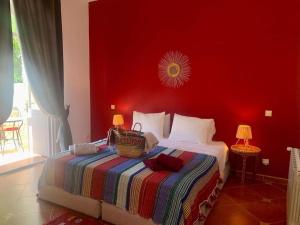1 dormitorio con 1 cama con pared roja en Le Domaine d'Eden - Villa luxueuse, piscine, spa et personnel, en Essaouira